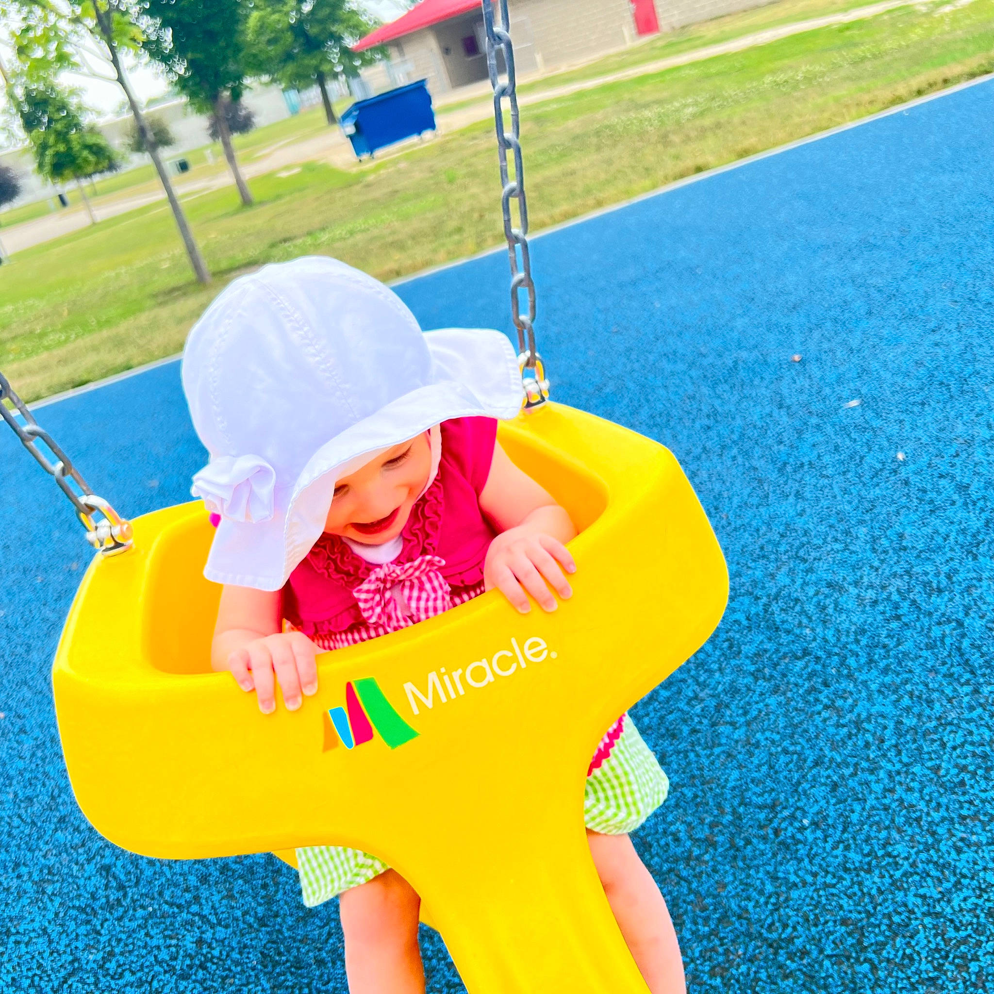 Cecilia is registered to the contest to win money with this photo: baby, baby_toddler_clothing, blue, city, electric_blue, fun, grass, happy, hat, human_settlement, leisure, people_in_nature, person, plant, playground, public_space, recreation, sun_hat, swing, toddler