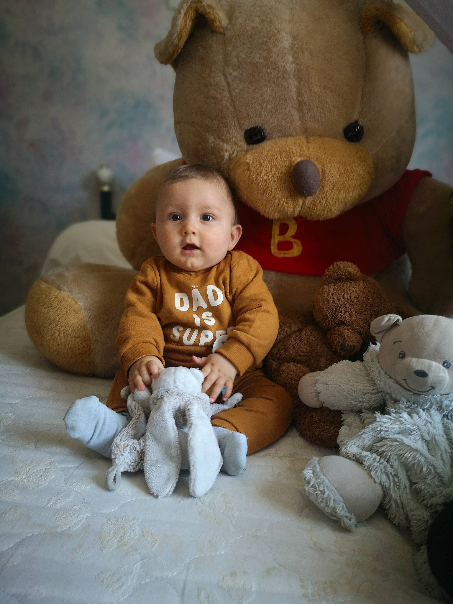 Manolo a rejoint le concours — aidez-le/la à gagner de superbes lots ! baby, baby_toddler_clothing, cheek, child, comfort, fur, happy, head, mammal, person, plush, room, sitting, stuffed_toy, teddy_bear, textile, toddler, toy, vertebrate, white