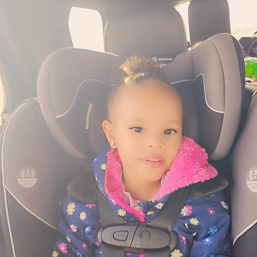 Nevaeh is registered to the contest to win money with this photo: accessories, baby, belt, car, car_interior, carseat, clothing, coat, cushion, face, head, headrest, homedecor, jacket, person, photography, portrait, sitting, transportation, vehicle