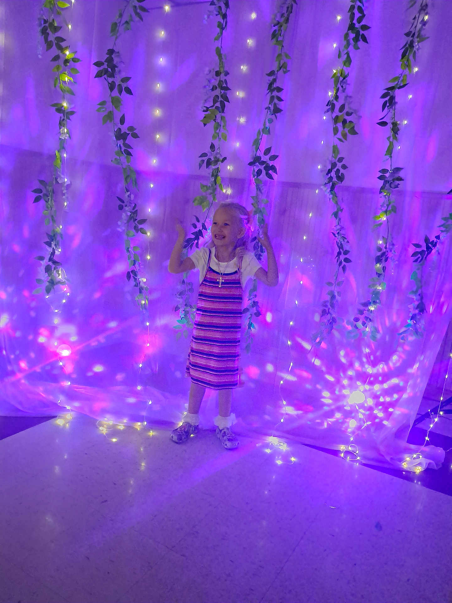 Ashy joined the competition — help win amazing prizes! child, girl, dress, smiling, fairy_lights, purple_light, vines, indoor, floor, happy, standing, decorations, magic, glow, young, person, playful, lighting, celebration, background