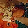 baby, sleeping, onesie, floral, infant, play_mat, cartoon, octopus, fish, colorful, cozy, child, peaceful, indoors, portrait, cute, young, resting, soft_lighting, nursery