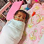 baby, infant, swaddled, blanket, crib, medical_tubes, pink_pillow, cartoon_pattern, face, resting, indoors, healthcare, child, cute, sleeping, hospital, equipment, tubing, small, peaceful