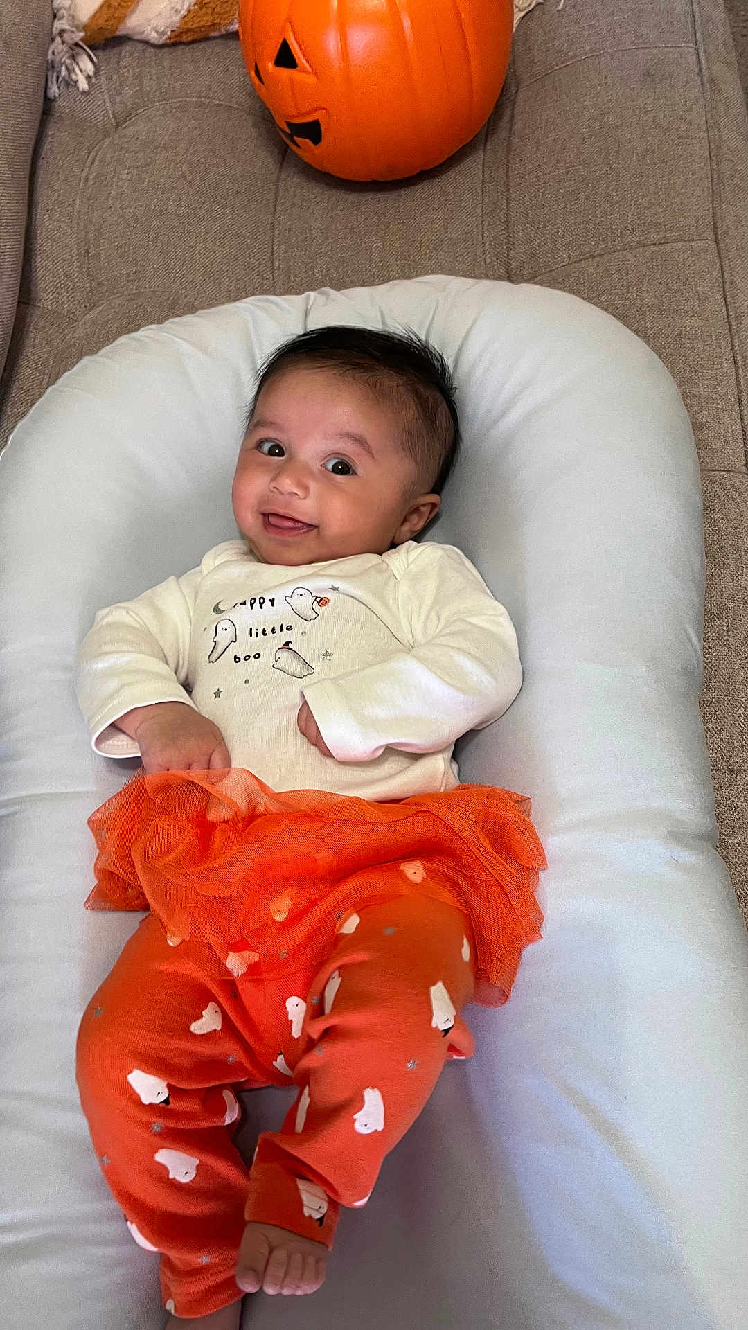 Aurora joined the competition — help win amazing prizes! baby, infant, smiling, halloween, pumpkin, jack_o_lantern, orange_clothing, ghost_pattern, tutu_skirt, white_cushion, couch, gray_fabric, indoors, cute, child, happy, portrait, holiday, festive, cozy