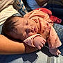 Rosalia a rejoint le concours — aidez-le/la à gagner de superbes lots ! baby, newborn, sleeping, infant, pink_clothing, arm, tattoo, hand, human_skin, person, rest, closeup, soft_lighting, indoor, jeans, casual_clothing, peaceful, parent, holding, portrait