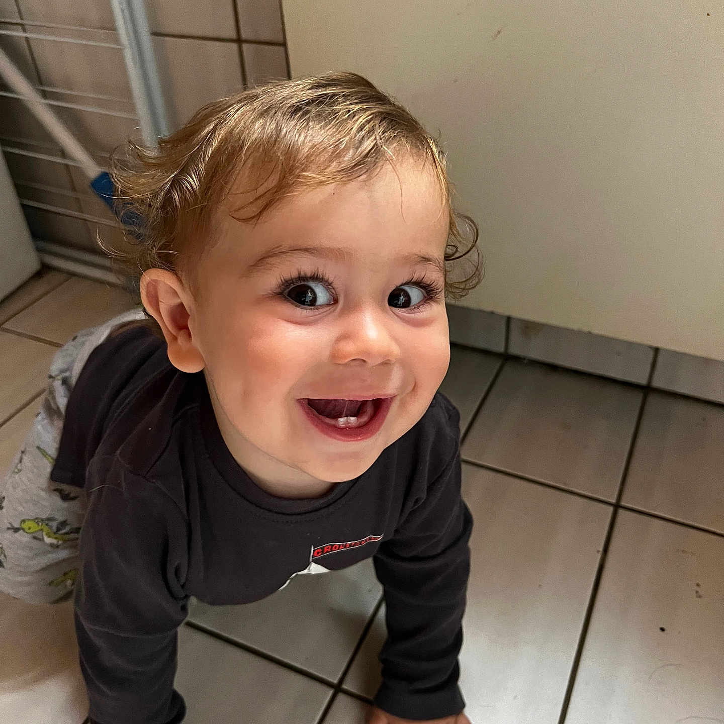 Maël participe au concours pour gagner de l'argent avec cette photo : baby, child, clothing, crawling, cute, expression, face, floor, hair, hands, happy, indoor, joyful, long_sleeve, pants, person, smiling, tile, toddler, young_child