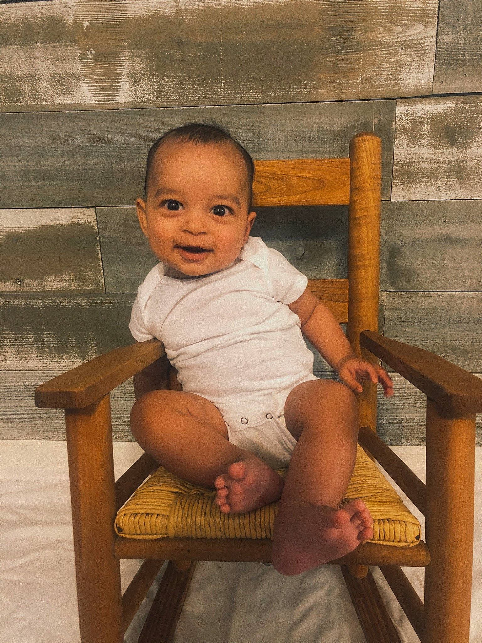Crue joined the competition — help win amazing prizes! baby, chair, child, chin, face, furniture, leg, person, sitting, skin, smile, toddler, vacation, wood