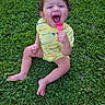 toddler, child, grass, outdoor, yellow_clothing, happy, smiling, toy, sitting, barefoot, curly_hair, person, playful, greenery, summer, cute, fun, youth, innocence, cheerful