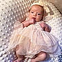 Maddie joined the competition — help win amazing prizes! baby, infant, pink_dress, headband, blanket, soft_texture, cute, newborn, portrait, indoors, sleepwear, tulle, small_hands, small_feet, lying_down, comfortable, adorable, child, face, expression