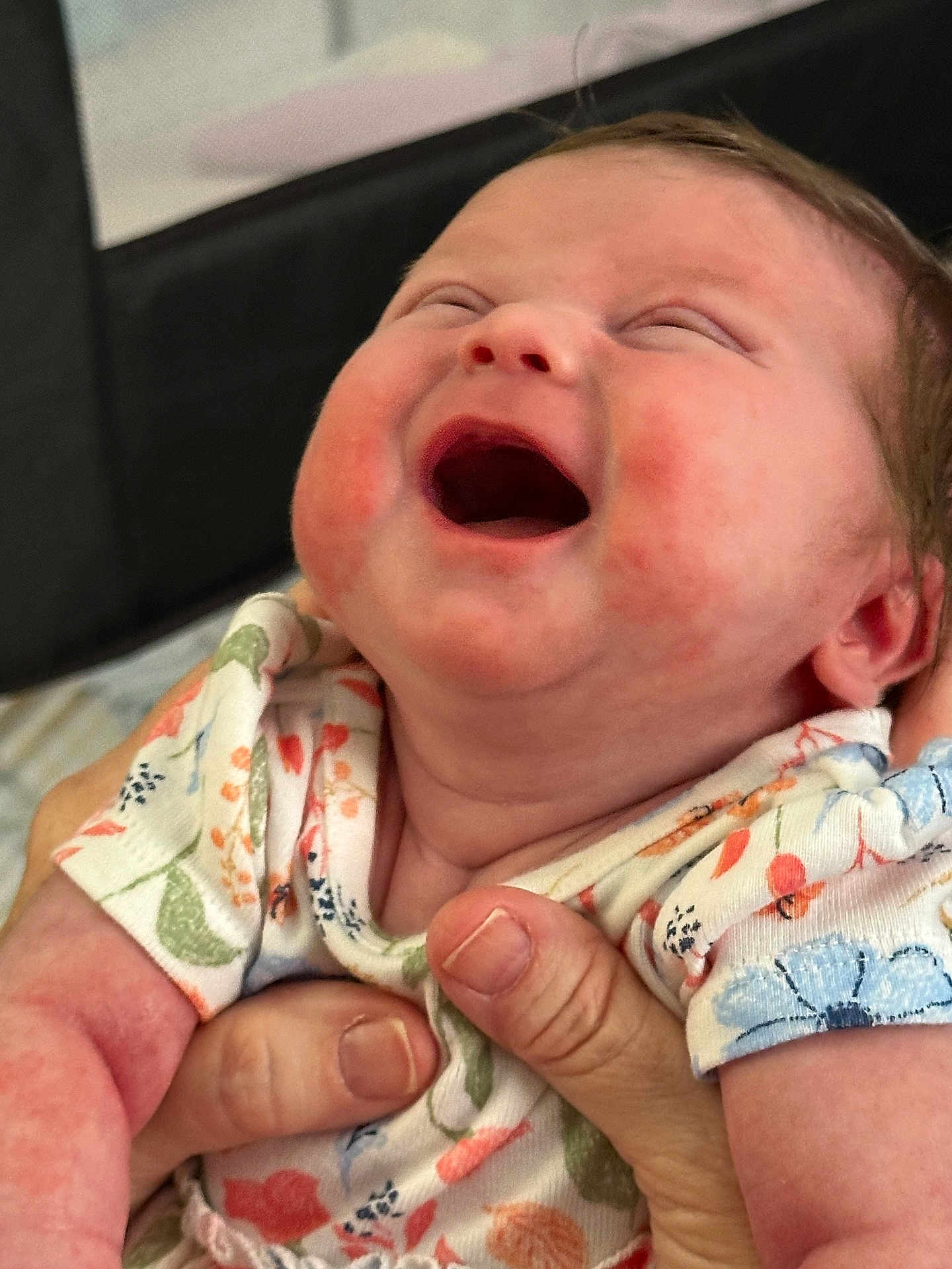 Ryhlee is registered to the contest to win money with this photo: baby, infant, smiling, laughing, child, hands, onesie, floral_pattern, cute, happy, cheeks, skin, person, closeup, portrait, newborn, joyful, expression, clothing, indoor