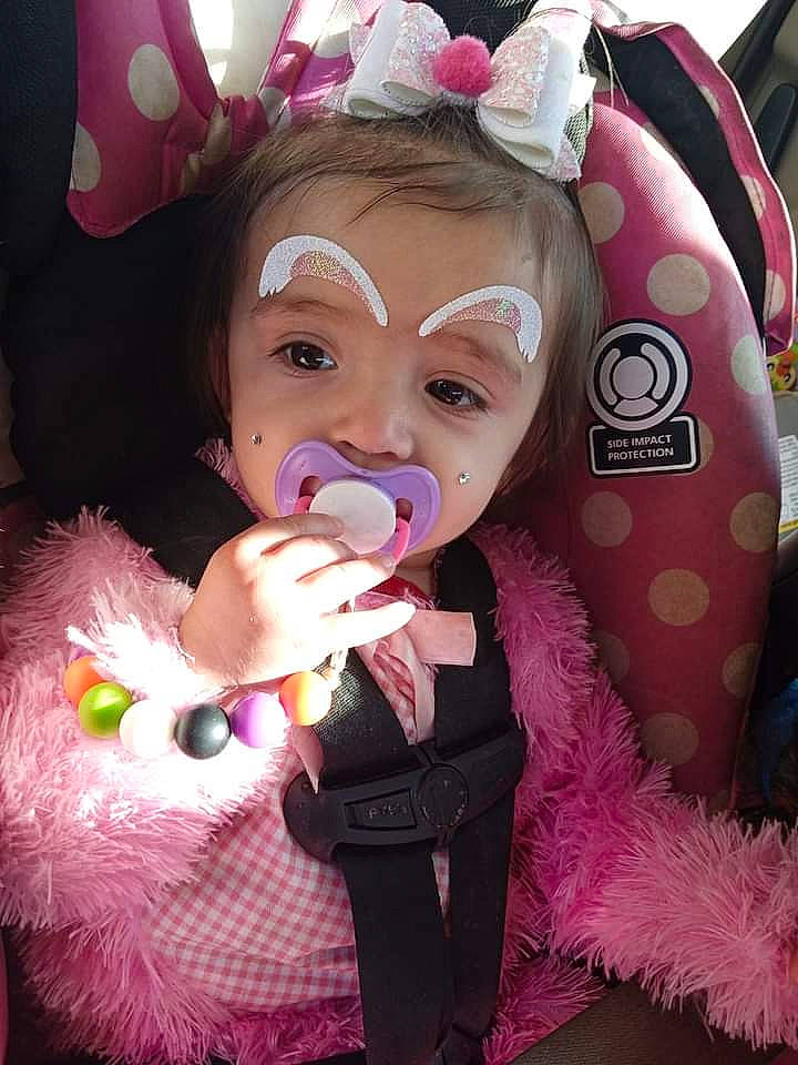 Emberly is registered to the contest to win money with this photo: child, costume, costume_hat, event, eyelash, facial_expression, fashion_accessory, fun, fur, gesture, happy, headpiece, lip, magenta, person, pink, purple, skin, textile, toddler
