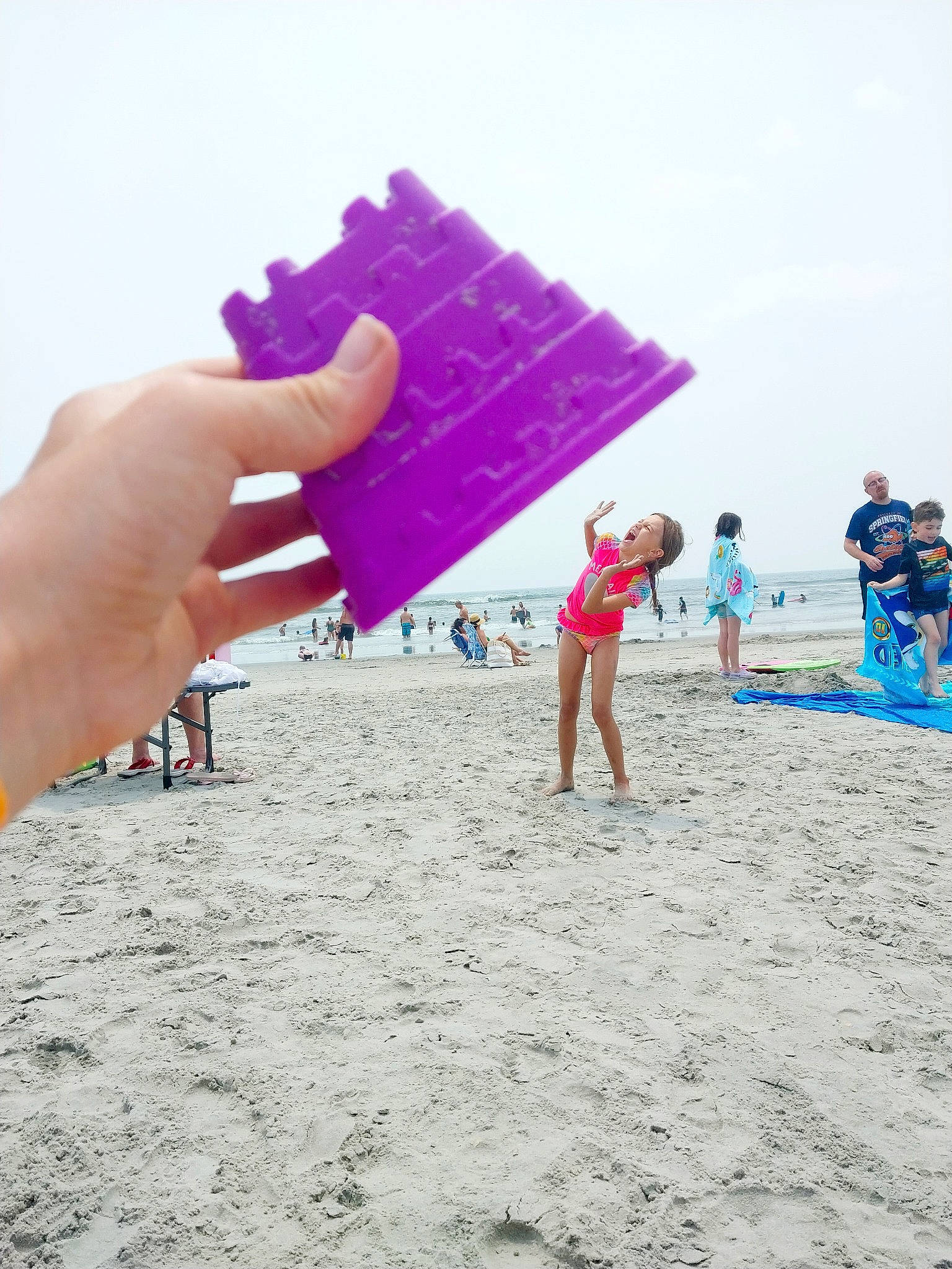 Jayde is registered to the contest to win money with this photo: beach, board_short, event, fun, gesture, holiday, leisure, magenta, nail, people_on_beach, person, recreation, sand, shorts, sky, summer, travel, trunks, umbrella, wind