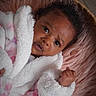 Madolyn is registered to the contest to win money with this photo: baby, infant, child, face, curly_hair, robe, blanket, basket, fur, soft_texture, pink, white, cozy, portrait, closeup, newborn, expression, cute, sleeping_area, indoors