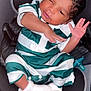 Adrian is registered to the contest to win money with this photo: baby, infant, car_seat, green_striped_clothing, white_booties, pacifier, dabbing, cute, child, newborn, sleepy, portrait, indoors, soft_lighting, person, young_child, adorable, small_hands, curly_hair, casual_clothing