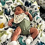 baby, newborn, sleeping, onesie, socks, blanket, dinosaur_pattern, infant, cute, soft, cozy, lying_down, child, indoors, peaceful, portrait, resting, toddler, clothing, fabric