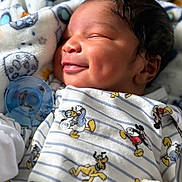 Adrian is registered to the contest to win money with this photo: baby, newborn, smiling, pacifier, blanket, mickey_mouse, donald_duck, pluto, cozy, sleeping, cute, infant, child, soft, patterned_clothing, indoors, portrait, closeup, dimples, warm
