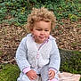 Filip is registered to the contest to win money with this photo: child, toddler, curly_hair, forest, moss, rock, leaves, greenery, outdoor, nature, socks, sandals, fleece_jacket, blanket, sitting, smiling, autumn, young_child, casual_clothing, daylight