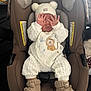 Austin joined the competition — help win amazing prizes! baby, infant, car_seat, onesie, knit_hat, booties, hands_over_face, peekaboo, lion_embroidery, evenflo_brand, brown_car_seat, cozy, newborn, cute, portrait, indoors, safety_label, quilted_clothing, soft_texture, seat_padding
