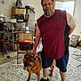 Anya Bug is registered to the contest to win money with this photo: beard, chair, clutter, crocs, dog, door, garage, german_shepherd, happy, indoor, man, pet, rug, shoe, shorts, sleeveless_shirt, standing, storage_boxes, tattoo, tongue_out
