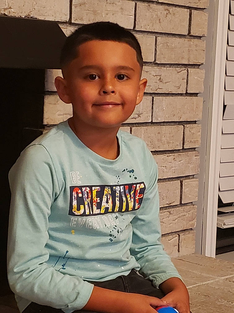 Silas joined the competition — help win amazing prizes! brick, brickwork, cheek, child, chin, cool, facial_expression, forehead, fun, happy, head, joy, leisure, neck, person, shirt, sitting, sleeve, smile, t_shirt