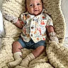 baby, bed, blanket, child, clothing, cozy, cute, face, happy, indoors, infant, lobster_print, photography, plush, portrait, shorts, sitting, smiling, socks, striped_mittens