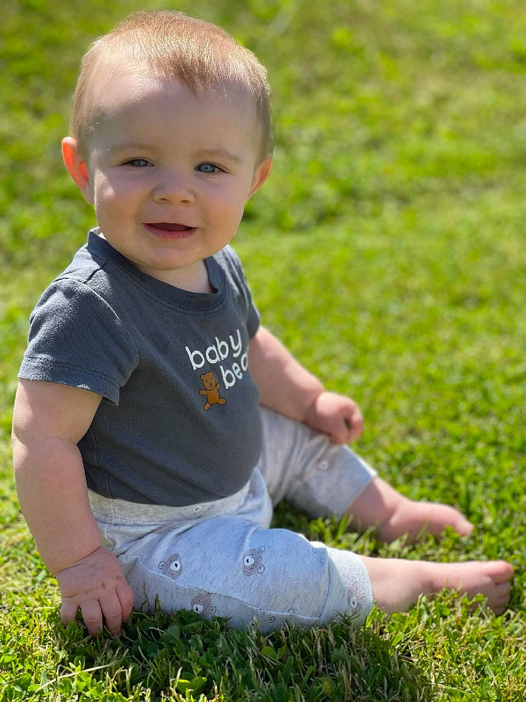 Tylan is registered to the contest to win money with this photo: baby, baby_toddler_clothing, face, finger, fun, grass, grass_family, grassland, groundcover, happy, joy, lawn, leg, leisure, meadow, people_in_nature, person, plant, smile, t_shirt