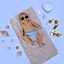 baby, sunglasses, towel, seashells, hat, striped_clothing, bare_chest, infant, relaxing, summer, beach_theme, lying_down, accessories, cute, small_person, skin, footwear_absent, outdoor, sun_protection, portrait