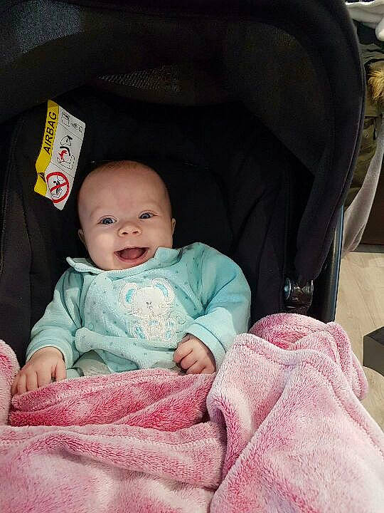 Roxane participe au concours pour gagner de l'argent avec cette photo : baby, baby_carriage, baby_in_car_seat, baby_products, baby_toddler_clothing, car_seat, cheek, child, comfort, head, lap, linens, magenta, person, pink, sitting, skin, sleeve, smile, textile