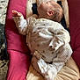 newborn, baby, sleeping, infant, onesie, baby_rocker, cushion, red, white, floral_pattern, peaceful, indoors, floor, head, hand, foot, clothing, resting, child, portrait