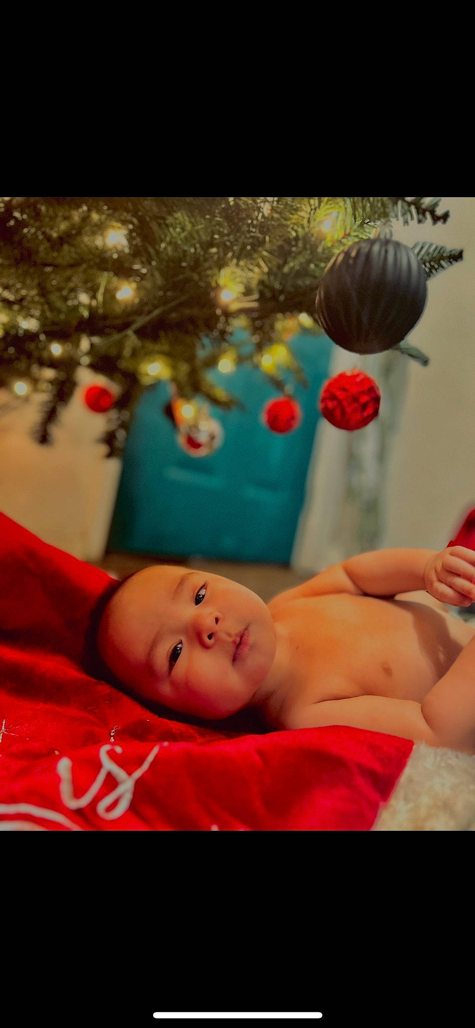 Josiah is registered to the contest to win money with this photo: abdomen, baby, barefoot, chest, child, event, foot, fun, happy, holiday, human_body, leisure, mouth, person, play, portrait_photography, red, room, sitting, smile