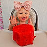 baby, child, high_chair, bow, watermelon, fruit, happy, smiling, hand, face, cute, food, summer, pink, patterned_curtain, jewelry, bracelet, indoor, portrait, toddler