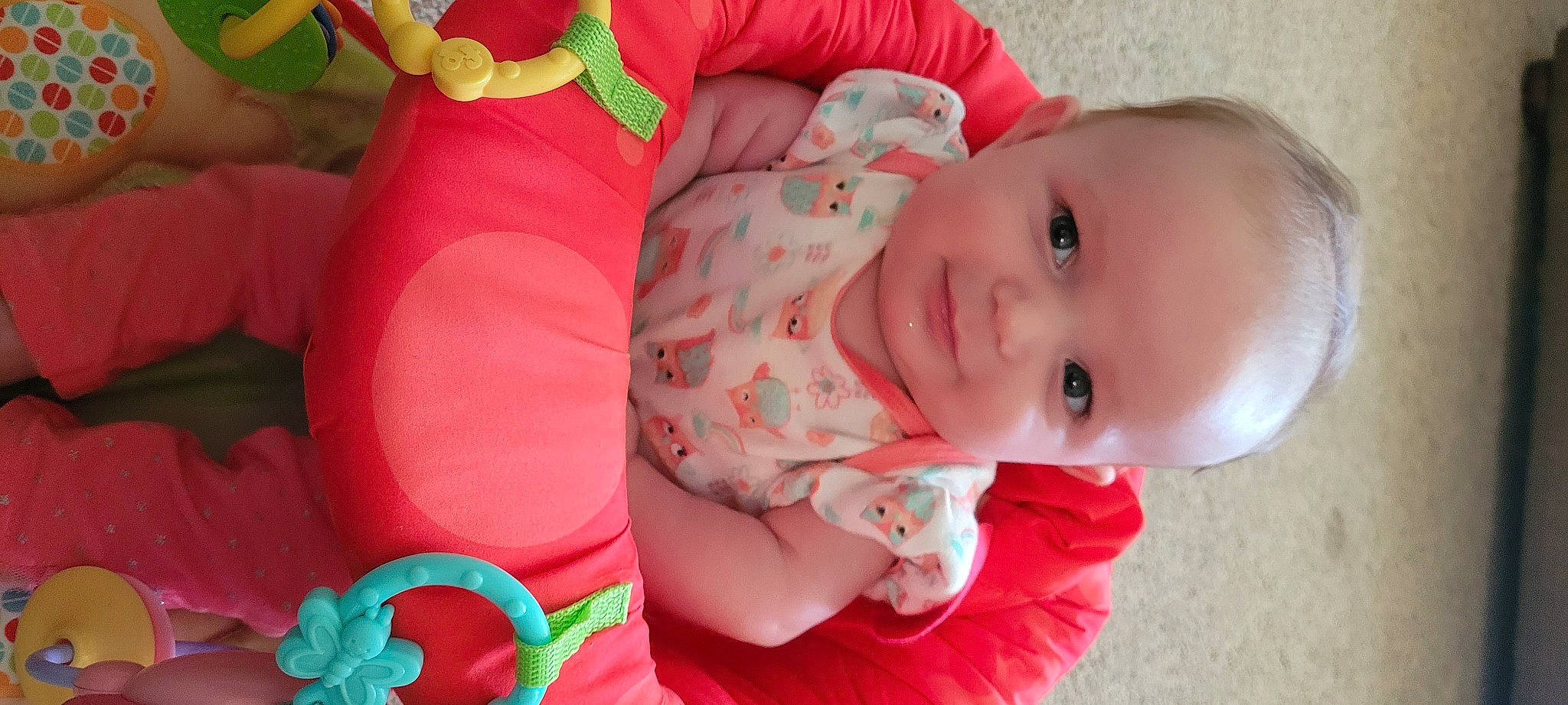 Raven is registered to the contest to win money with this photo: baby, baby_toddler_clothing, cheek, eye, finger, green, happy, human_body, iris, lip, mouth, nose, orange, person, pink, product, red, skin, smile, textile