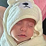 baby, sleeping, towel, hood, bear_design, soft_texture, closeup, face, child, infant, cute, wrapped, pink_background, calm, peaceful, skin, mouth, nose, eyelashes, blanket