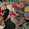 babies, bed, blankets, children, clothing, colorful, family, home, indoors, infants, lying_down, nursery, pacifier, pillows, portrait, rattle, sitting, smiling, stuffed_toys, twins