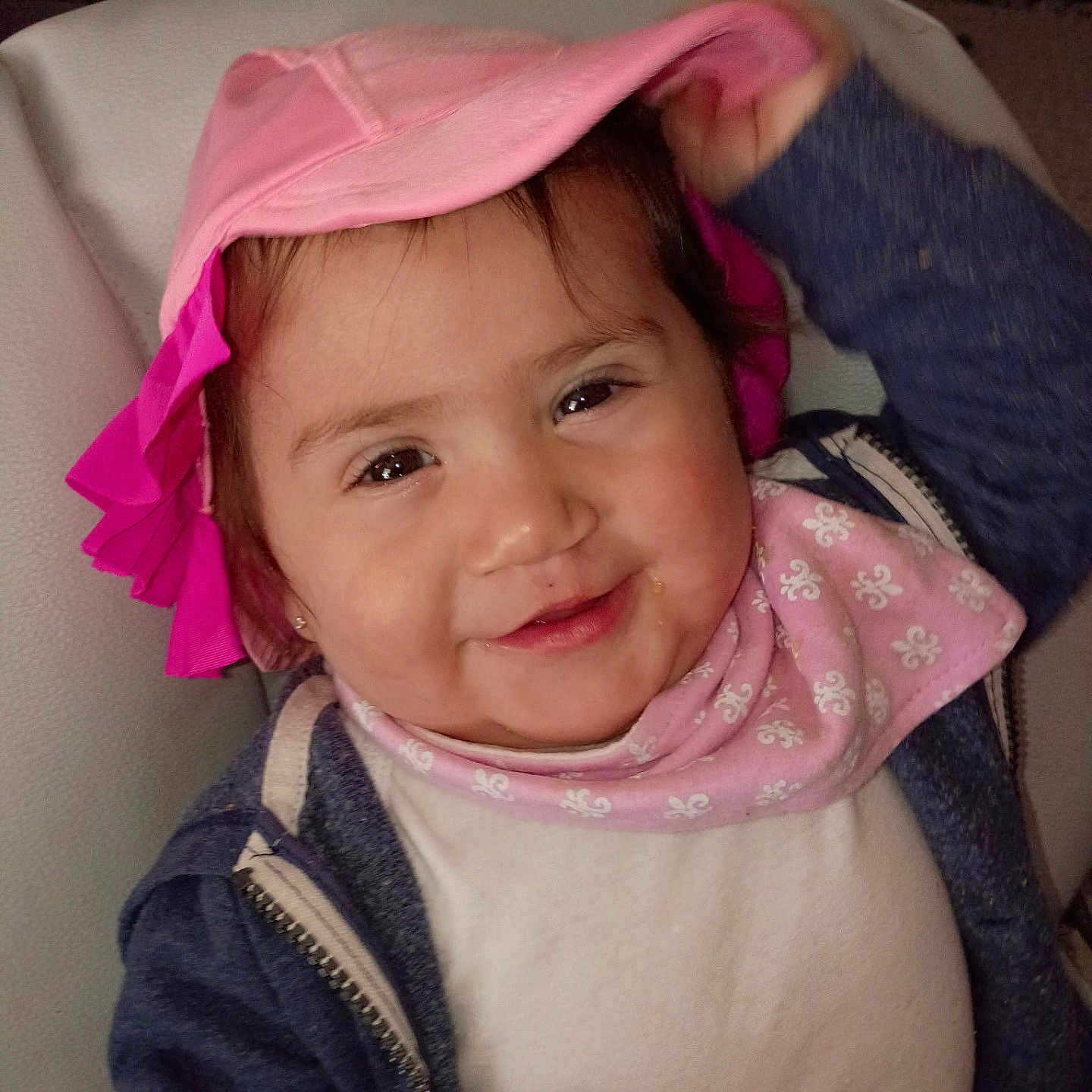 Ayla is registered to the contest to win money with this photo: toddler, child, smile, hat, pink, bib, clothing, indoor, face, person, cute, happy, jacket, baby, portrait, headwear, young_child, sitting, playful, cozy