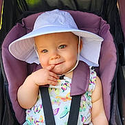 Karley joined the competition — help win amazing prizes! baby, child, stroller, hat, white_hat, purple_stroller, colorful_clothing, butterflies, birds, cute, smiling, playing, finger_on_lips, seatbelt, outdoor, summer, sunhat, infant, portrait, happy