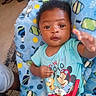 Elijah joined the competition — help win amazing prizes! baby, child, infant, blue_blanket, popsicle_pattern, mickey_mouse, cartoon, tshirt, indoor, floor, carpet, person, cute, smiling, lying_down, hand, curious, colorful, expression, young