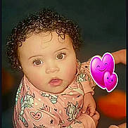 Laneisha joined the competition — help win amazing prizes! baby, child, curly_hair, cute, digital_emojis, expression, eyes, face, heart_pattern, indoor, infant, looking_up, onesie, pink_clothing, portrait, purple_hearts, sitting, skin, unicorn_pattern, young