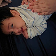 Jaziel is registered to the contest to win money with this photo: baby, infant, striped_clothing, hands, person, lying_down, bed, blue, skin, face, newborn, child, toddler, comfort, resting, cute, sleepwear, care, soft, family