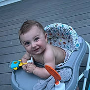 Jasper joined the competition — help win amazing prizes! baby, child, toddler, smiling, happy, portrait, face, outdoor, deck, wooden_deck, activity_walker, baby_walker, toy, colorful_toy, towel, seated, infant, house, siding, bucket