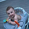 baby, child, toddler, smiling, happy, portrait, face, outdoor, deck, wooden_deck, activity_walker, baby_walker, toy, colorful_toy, towel, seated, infant, house, siding, bucket