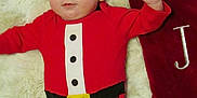 Jasper joined the competition — help win amazing prizes! baby, infant, red_onesie, santa_costume, christmas_stocking, blanket, fluffy, cute, holiday, festive, lying_down, indoors, portrait, child, soft_texture, warm_colors, decor, celebration, smile, happy
