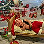 Jasper joined the competition — help win amazing prizes! baby, infant, christmas, holiday, santa_hat, santa_outfit, bed, wooden_bed, blanket, cookies, baby_bottle, christmas_tree, presents, decorations, festive, smiling, indoor, floor, toy, cute