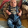 Jasper joined the competition — help win amazing prizes! baby, infant, clothing, striped_shirt, blue_jeans, suspenders, blanket, cozy, indoor, bed, socks, cute, portrait, person, young_child, comfort, relaxed, face, hands, lying_down