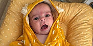 Raphaël participe au concours pour gagner de l'argent avec cette photo : baby, basket, blanket, child, cozy, curious_expression, cushion, cute, footwear, hand, hooded_towel, indoor, infant, open_mouth, person, plush_toy, soft_fabric, white_dots, wooden_floor, yellow_towel