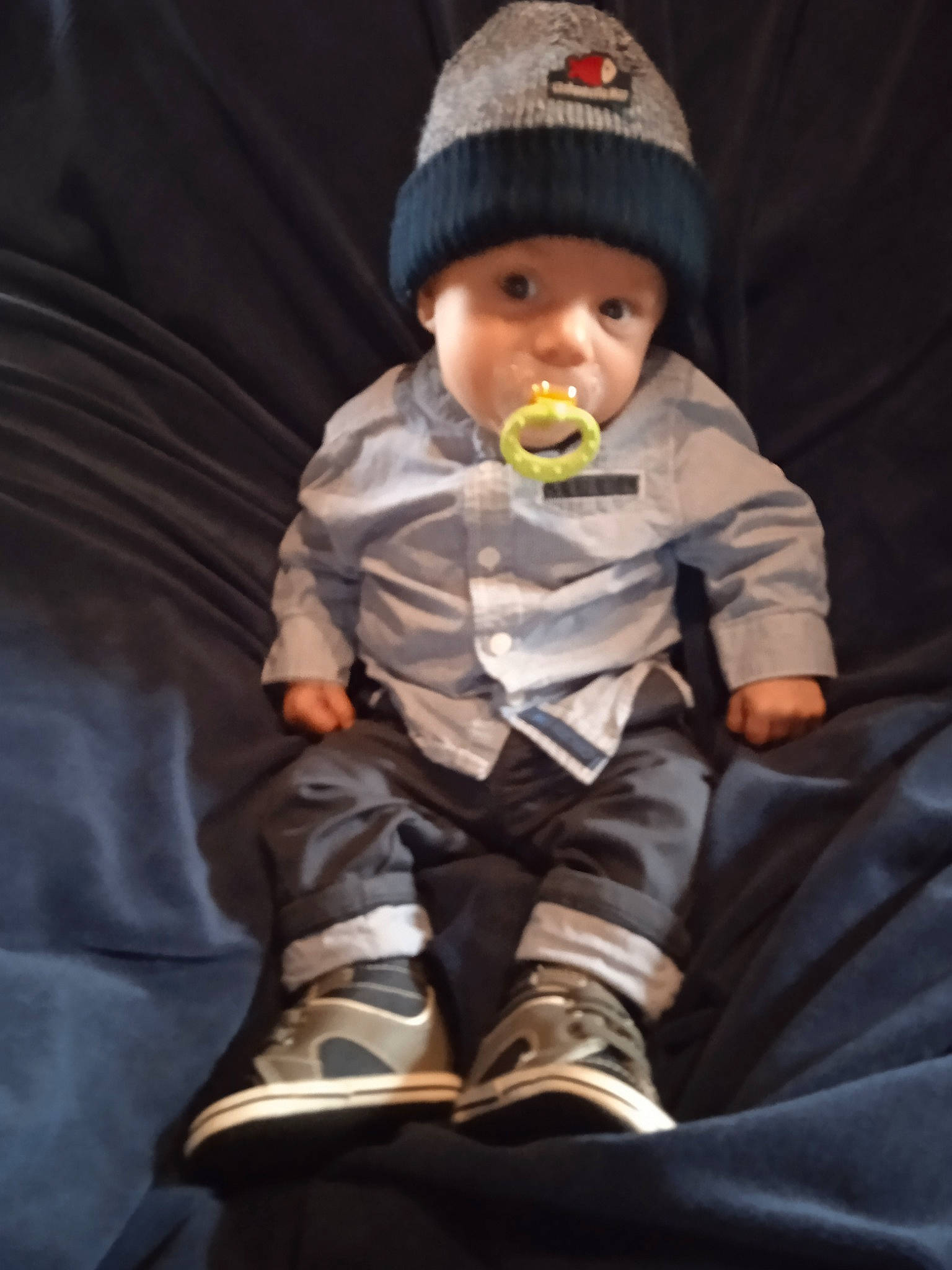 Tiago participe au concours pour gagner de l'argent avec cette photo : baby, baby_carriage, baby_toddler_clothing, cap, carmine, cheek, child, comfort, cool, finger, fun, headwear, lap, outerwear, person, personal_protective_equipment, shoe, sitting, skin, sleeve