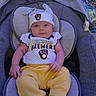 baby, infant, child, car_seat, portrait, smiling, looking_at_camera, baseball, milwaukee_brewers, sportswear, hat, onesie, yellow_clothing, purple, indoor, seated, blanket, canopy, baby_clothing, happy