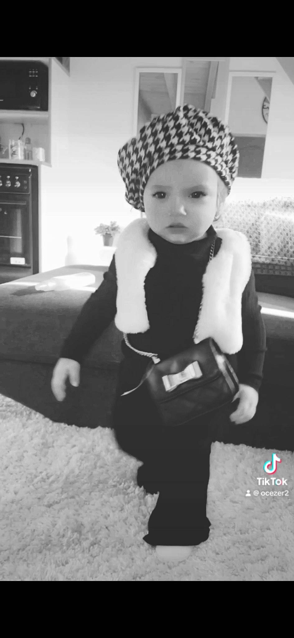 Yliana a rejoint le concours — aidez-le/la à gagner de superbes lots ! baby, baby_toddler_clothing, beanie, black_and_white, cabinetry, cap, child, fashion_accessory, flash_photography, fur, headband, headgear, headwear, home_appliance, knit_cap, monochrome, monochrome_photography, person, sitting, sleeve