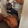 Lola joined the competition — help win amazing prizes! puppy, dog, pet, indoor, carpet, person, legs, shorts, sitting, cute, young_dog, black_dog, tan_dog, small_dog, canine, companion, home, relaxed, casual, curious