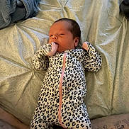 Wrenley joined the competition — help win amazing prizes! baby, infant, onesie, leopard_print, bed, blanket, sleepy, hand, tattoo, skin, person, lying_down, indoors, cute, newborn, clothing, pattern, human, resting, comfort