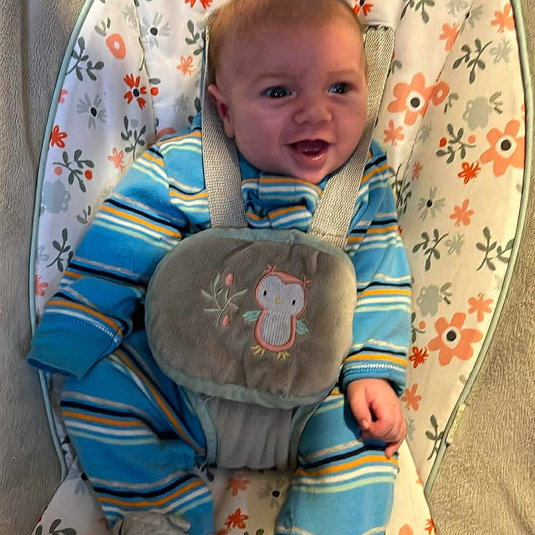 Richard Allen joined the competition — help win amazing prizes! baby, infant, smile, blue_onesie, striped_clothing, baby_rocker, floral_pattern, baby_slippers, cute, happy, child, indoor, portrait, seated, fabric, soft_toys, baby_buckle, comfort, playful, adorable